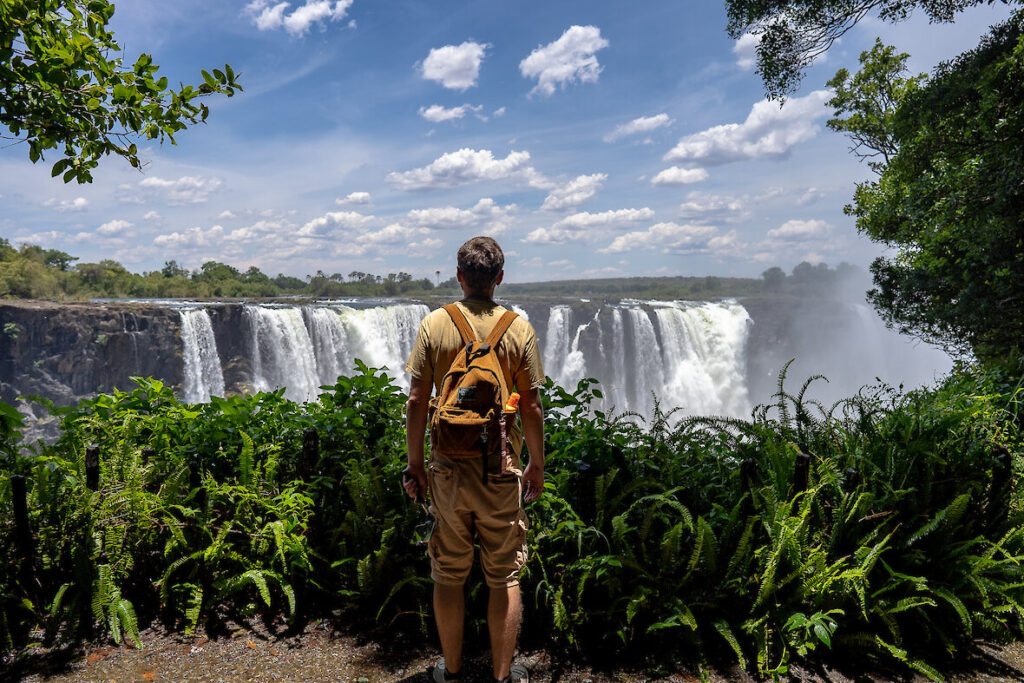 mann steht an aussichtspunkt zu den victoria faellen.1180x0
